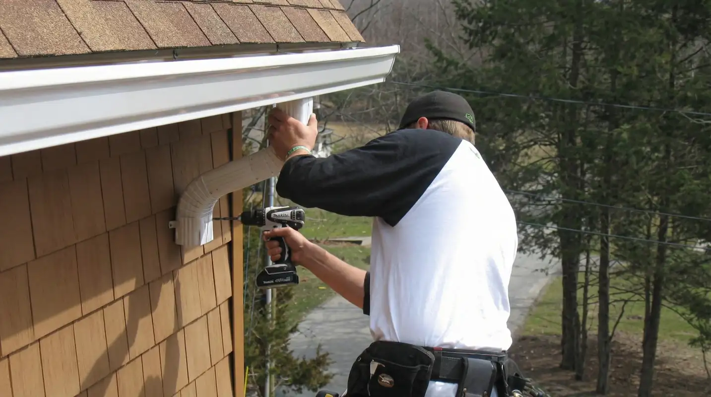 Professional contractor installing tan vinyl siding panels on a residential home exterior in Myrtle Beach, SC